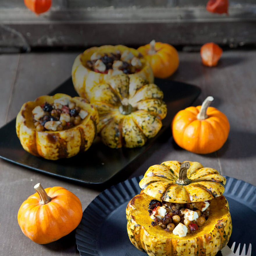 Gefüllte kleine Kürbisse mit würziger Hackfleischfüllung, Kichererbsen, Paprika, Rosinen und Feta, herbstlich angerichtet.