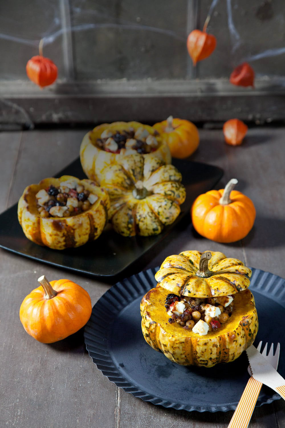 Gefüllte kleine Kürbisse mit würziger Hackfleischfüllung, Kichererbsen, Paprika, Rosinen und Feta, herbstlich angerichtet.